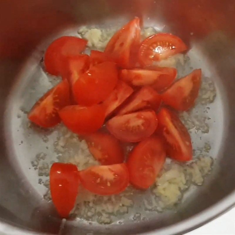 Bạn xào cà chua để chuẩn bị nấu nước dùng