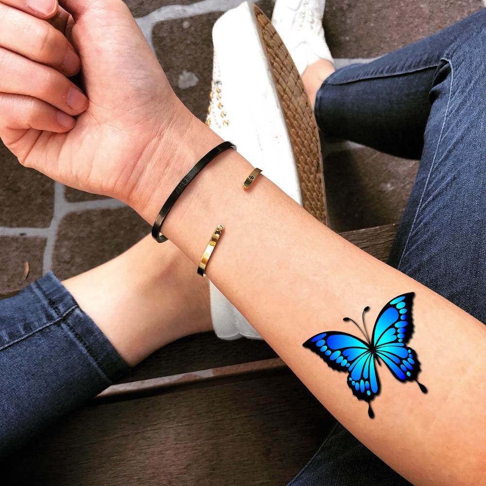 Một hình xăm bướm xanh trên cổ tay