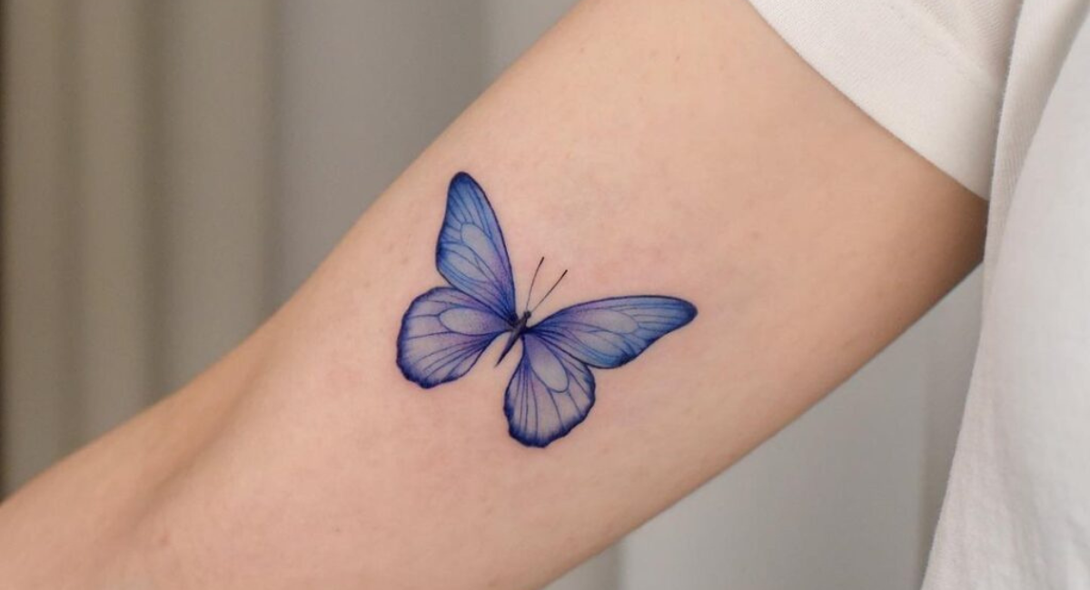 Một chú bướm màu xanh trên cánh tay thật tuyệt vời