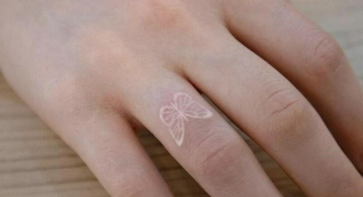 Hình xăm bướm trắng nhỏ trên ngón tay