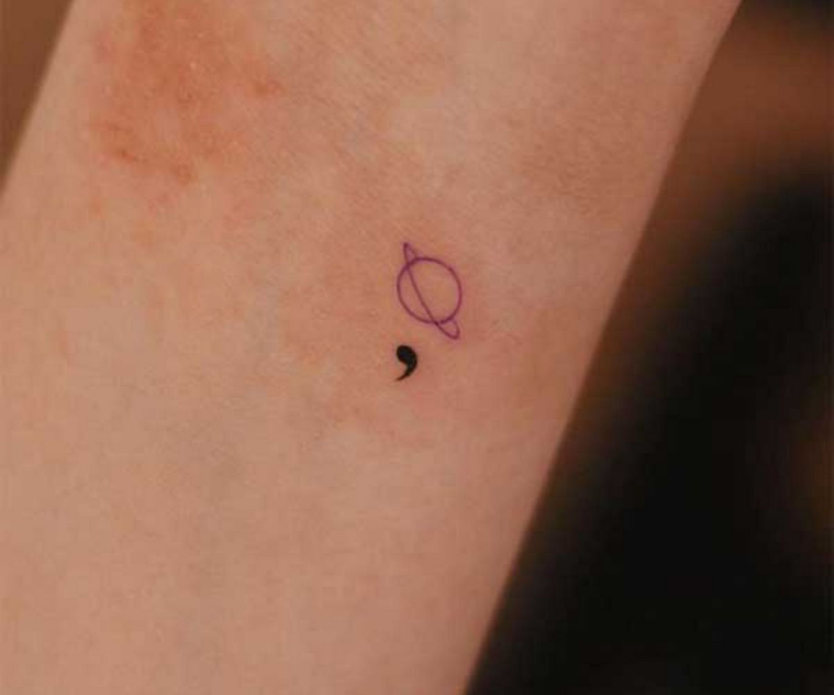 Mẫu xăm dấu chấm phẩy mini kết hợp với hành tinh trên cổ tay cho nữ