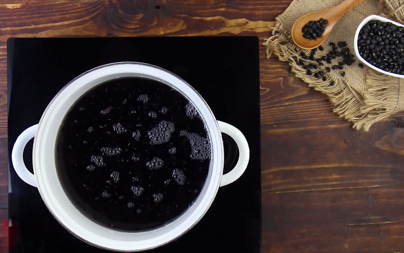 Đun đậu đen trên bếp khi thấy đậu mềm thì thêm đường